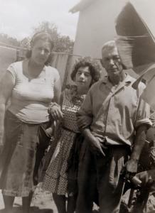 Déa (ao centro), junto à madrasta Marieta e o pai Décio, no quintal de sua casa, vestida a caráter para ir à Festa Junina da Companhia de Telecomunicações do Brasil Central (CTBC).