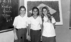 Nilva Apossidônia na sala de aula com duas colegas, na quarta série. Nilva está à esquerda, Vera Lúcia no centro, e Radige à direita.