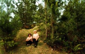 Sueli e Carmen (esq./dir.) sentadas no gramado em retiro da Igreja de Cristo, local onde há muito verde. O lugar pertence, à época, à Igreja Batista e antes era um hospital psiquiátrico, por isso conta com muitos quartos e cômodos.