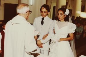 Casamento de Tarso e Vanila, eles estão no altar, de frente para o padre que está realizando cerimônia