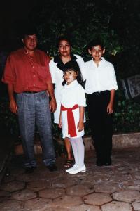 Estão ao lado uns dos outros, Mariana está na frente. Eles tinham acabado de chegar de um casamento e aproveitaram para tirar a foto em frente ao jardim do vizinho
