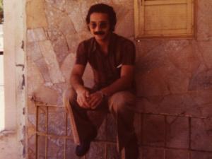 Durval está sentado numa grade, em frente a uma casa. Morava em uma repúlica, próxima a casa de Luiz Garcia