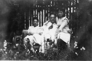 Paulina com os pais no jardim da sua casa.