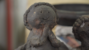 Anjinho em barro queimado, moldado manualmente com traços simples e expressivos, revelando as marcas do fazer artesanal. A peça foi produzida por Mariana Barboza, filha de Jucileia, ainda na infância, enquanto ela acompanhava a mãe na Associação. É preservada por Jucileia Barboza como memória afetiva e expressão de um saber que atravessa gerações. Inserida no contexto das Paneleiras de Goiabeiras, a imagem carrega a delicadeza do gesto e a força da tradição cerâmica local.