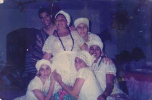 Mãe Neia cercada por suas filhas e filhos de santo.