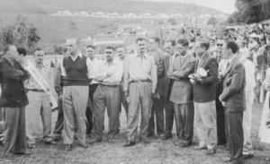 Carlos ao lado do campeão interno com a faixa e o superintendente de taça na mão do Clube Valeriodoce. Ao fundo, se avista o Cauê.