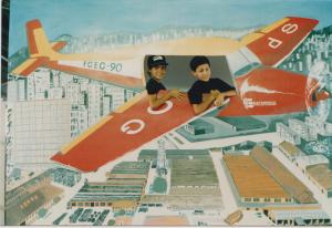 Thiago (à esquerda), o filho de Cláudio, posa para foto em um painel com desenho de avião durante a confraternização de final de ano dos funcionários da Eletropaulo.