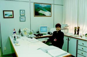 Ana Maria em seu trabalho onde se pode ver os quadros pintados por sua filha Ana Letícia, o escritório fica no centro executivo, Vila A. Nesta época, Ana Maria já trabalhava como secretária da Diretoria Executiva, cargo que assumiu em maio de 1995 a convite de Scalvo.