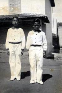Eishim Uezato e Matsuki Oiakuso, com o uniforme do Colégio Profissional, em frente à pensão onde moravam, na Rua 13 de Maio. Araraquara, SP, década de 30. Eishim fez mecânica no Núcleo de Ensino Profissional de Araraquara.Na época com 12/13 anos.