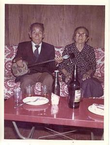 O sogro de Eishim Uezato tocando samissem (viola japonesa) e sua sogra, em sua casa. Araraquara, SP, década de 60.