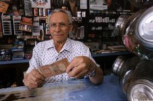 Olívio Alves Bezerra, no Bar do Pernambuco, com a nota de peso chileno que Jean-Paul Sartre utilizou para pagar um café. Araraquara, SP, 1999.
