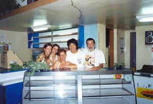 Perla, Paula e Gracinha Horta, Teru (fã coreano e amigo de Toninho) e Paulo Horta no bar “Aqui Ó”.  Escondido entre becos do bairro Horto na zona leste de Belo Horizonte, o bar “Aqui Ó” é surpreendente para os fãs de boa música. Comandado por Gracinha Horta (esposa do falecido Paulo Horta) e suas filhas, este bar recebe as quartas-feiras grandes nomes da MPB como o próprio Toninho que comanda as guitarras, o baterista Esdras (Nenê Batera), o contrabaixista Paulinho Carvalho entre outros. Volta e meia observa-se também entre os frequentadores do bar grandes músicos e compositores como Tadeu Franco, Fernando Brant, Márcio Borges, etc. Gracinha Horta, cunhada de Toninho, também é cantora profissional desde os 15 anos e em um ritmo descontraído, onde diversos músicos presentes fazem uma “canja”, Gracinha também se apresenta mostrando sua bela voz.