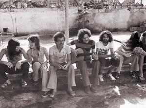 Os Novos Baianos - Pepeu Gomes, Dadi, Galvão, Moraes Moreira, Paulinho Boca de Cantor e Baby Consuelo - na casa de Toninho Horta. Na Bahia dos anos 60, um grupo de jovens músicos - Baby (então Consuelo, hoje do Brasil), Pepeu Gomes, Moraes Moreira, Dadi, Galvão, Paulinho Boca de Cantor, Jorginho, Baixinho e Bolacha - criou os Novos Baianos. Desde o princípio a proposta era consistente e os Novos inovavam sem ser ingênuos. No início dos 70, passaram pela “migração musical” a que todos os artistas nordestinos daquela época eram levados, indo para o Rio de Janeiro. Em seus primeiros momentos no Rio, os baianos eram visitados constantemente por João Gilberto, o que influenciou bastante o grupo, quando o Rock passou a ceder espaço para a MPB. Em 78 o grupo foi desfeito, mas quase todos os integrantes permaneceram seguindo carreira solo.