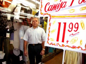 legenda: Claudio Fadel em frenbte à sua loja.