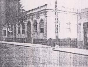 Fachada da casa onde Olympia e seus irmãos nasceram e também onde sua mãe casou. Ela foi construída pelo comendador Zeferino da Costa Guimarães, avô de Olympia, e foi derrubada pouco tempo após esse registro, ainda na década de 50. A fotografia foi tirada por Olympia através de uma Baby Box Zeiss e a casa ficava no Largo da Matriz, na atual rua Barão do Rio Branco.