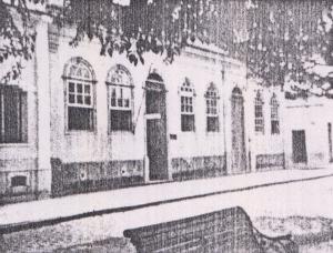 Fachada da casa onde Olympia e seus irmãos nasceram e também onde sua mãe casou. Ela foi construída pelo comendador Zeferino da Costa Guimarães, avô de Olympia, e foi derrubada pouco tempo após esse registro, ainda na década de 50. A fotografia foi tirada por Olympia através de uma Baby Box Zeiss e a casa ficava no Largo da Matriz, na atual rua Barão do Rio Branco.