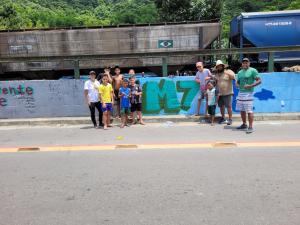 Na Vila Esperança, Patrícia se une às crianças para transformar muros em poesia visual. Entre risadas e pinceladas, a presença vibrante da garotada do time de futebol M7 trouxe ainda mais vida ao projeto. Cada traço no muro é mais do que tinta: é memória, é identidade, é a marca de uma juventude que acredita na beleza de sua comunidade. A fotografia captura não apenas o ato de grafitar, mas o encontro de gerações que, juntas, reinventam o espaço urbano em dezembro de 2024.