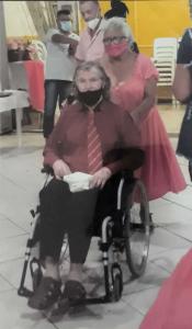 A imagem registra o casamento de Dona Cícera e Tigrão, realizado durante o período da pandemia. Embora já compartilhassem décadas de vida em comum, o casal ainda não havia oficializado legalmente a união. Segundo relato de Dona Cícera, a cerimônia foi organizada como uma surpresa pelas irmãs da igreja, que transformaram o que seria um encontro íntimo em uma celebração comunitária marcante. Na época, Tigrão já se encontrava bastante debilitado e era cuidado por Cícera com dedicação. O registro carrega não apenas o simbolismo da oficialização, mas também o afeto coletivo e a rede de apoio que permeia as relações na Vila Esperança.