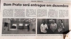 Matéria jornalística documentando a construção do restaurante popular Bom Prato, prestes a ser entregue à população. A reportagem destaca que o projeto foi resultado da articulação entre lideranças comunitárias, com Zumbi à frente, e o prefeito da época, Ademário. A iniciativa representa uma conquista significativa para a cidade, especialmente para a população da Vila Esperança, historicamente marcada pela fome e pela insegurança alimentar.