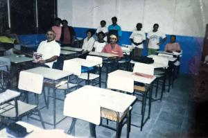 A imagem documenta uma das oficinas promovidas pela Sociedade de Melhoramentos do Jardim Ilha Bela, presidida por Zumbi na Vila Esperança. Esses cursos tinham como objetivo ampliar conhecimentos e oferecer ferramentas para que moradores pudessem melhorar suas condições de vida. A fotografia evidencia a compreensão de Zumbi de que a educação e a formalização eram caminhos fundamentais para transformar a realidade comunitária.