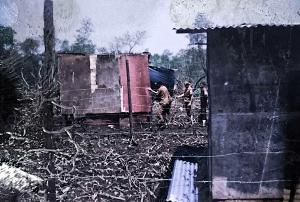 A fotografia registra o momento em que fiscais da prefeitura, conhecidos pela comunidade como “amendoins”, chegavam para inspecionar os barracos e determinar possíveis derrubadas devido às chamadas invasões. Zumbi lembra que as famílias se articulavam para criar estratégias de defesa e proteção de suas casas. A imagem revela a tensão e a permanência da luta cotidiana por moradia digna na década de 1980.