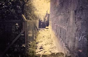 A imagem registra parte da cerca construída como medida pública para conter novas ocupações na área do mangue onde fica a Vila Esperança. A estrutura, localizada atrás da casa de Dona Martinha, simboliza tanto as limitações impostas pelo poder público quanto o desejo da comunidade de permanecer e conquistar urbanização digna. A fotografia preserva esse momento de tensão e de luta pelo direito à moradia.