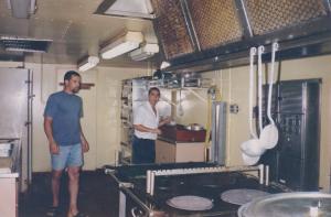 Na cozinha do navio Doce River. Na foto está ajudando a preparar a festinha de 9 anos do Adriel (filho  do  segundo oficial de máquina que está ao seu lado, não se recorda o nome).