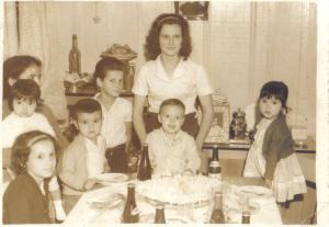 personagem: Minha mãe Maria, atrás de mim. Naor, Bernadeth, Paulinho, Bize e minha tia Zuleide.<br>historia: Esta é minha foto aos dois anos. Foi tirada em preto e branco e nela estão pessoas que já não estão entre nós, com o meu primo Naor e a sua mãe Zuleide. Naor foi um primo muito especial na minha vida. Passamos toda a nossa infância juntos. Ele falecem em 27 de agosto de 2006, dois dias depois do meu aniversário. Eu senti muito a sua morte, ele me deixou saudades.<br>