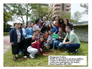 personagem: Poetas participantes do IX Congresso Brasileiro de Poesia, em Bento Gonçalves-RS.<br>historia: Durante o plantio de uma PITANGUEIRA POÉTICA, projeto criado por mim, durante o IX Congresso Brasileiro de Poesia. Reunimos poetas participantes para o plantio, em praça pública, de uma árvore frutífera, como símbolo da poesia que brota nesses encontros. Não lembro o nome de todos, mas podemos ver Marisa Scrocco (acocorada, de blusa vermelha, poeta argentina), Lília Diniz (acocorada, de blusa listrada, ao centro, poeta de Brasília-DF), Eu (plantando, ao lado da placa do projeto), Hugo Pontes (acocorado, por trás da placa, poeta de Poços de Caldas-MG), Ademir Bacca (acocorado, de camisa verde, poeta e coordenador do evento, de Bento Gonçalves-RS) e Jeanne Mazza (agachada por trás do Bacca, artista plástica de Brasília-DF). Ao fundo, alguns poetas seguram a MALA DA FAMA, de Jiddu Saldanha.<br>