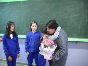 personagem: Eni, Letícia, Jenifer e Gabrieli.<br>historia: momento em que a neta Letícia abraça a avó logo após entregar as flores a homenageando.<br>