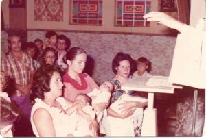 O batizado do seu filho aconteceu na Igreja São José, com as bênçãos do Padre Julinho. Adriano tinha 3 meses e seus padrinhos são Santa Rodrigues e Pedro Jacomini. As pessoas que estão com as crianças no colo, são mães que também estavam ali para o batizado de seus filhos.