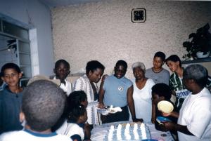 Aniversário de Amilcar, primogênito de Sônia. Ele estava rodeado de amigos e familiares na hora de cantar parabéns e cortar o bolo. (Esq. para dir.) O rapaz de camisa branca é o seu irmão mais novo, Giasy; sua tia Lurdes cortando o bolo; Amilcar; sua avó materna Balbina e ao redor estão os amigos e conhecidos da família.