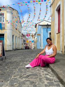 Milca no Pelourinho, em Salvador, Bahia, durante uma viagem, em 2022. Ela conta que essa viagem marcou um momento de conexão com sua ancestralidade, com a cidade, com o calor do povo e as religiões ali presentes. Em Salvador, Milca participou de oficinas de arte e fez um tour pela cidade com uma pesquisadora negra que contava sobre a história dos moradores negros da cidade soteropolitana.