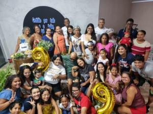 Comemoração do aniversário de 99 anos do avô paterno de Milca, em 2022. Ela conta que, apesar de não ter conseguido ir à festa, a fotografia representa suas raízes, sua estrutura e as várias gerações da família Soares. Seu pai está em pé, de camisa branca.