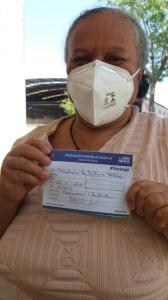 Marlucia com seu cartão de vacinação completo, apresentando a terceira dose da vacina contra a COVID-19, depois de um longo tempo em isolamento social.
