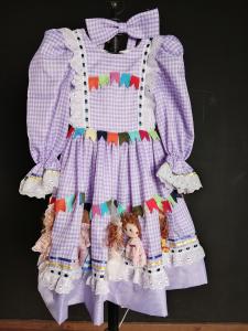 O amor de Marilda por esta data comemorativa é tão grande que ela começou a criar vestidos para este evento. Este vestido foi feito para Lívia dançar a quadrilha na festa junina do colégio EAC. Foi elaborado com 25 bonequinhos de feltro que representam os personagens da quadrilha, como os noivos, os pais dos noivos e as madrinhas amigas. Os bonecos foram bordados em volta de toda a saia do vestido. Marilda fez especialmente para essa ocasião, é uma peça única.