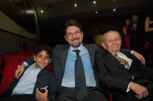 No momento de sua nomeação como governador do Acre, Binho aparece entre seu pai, Sr. Arnóbio, e seu filho, Gabriel. A fotografia reúne três gerações da mesma família em uma ocasião marcante de sua trajetória pública, registrando a presença e o apoio dos laços familiares em um momento de grande significado.