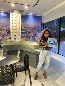 Juliane segurando o contrato de compra de seu primeiro apartamento, em 2020. Ela tinha o sonho de sair da casa dos pais e por meio da cunhada, que é corretora de imóveis, conseguiu financiar um imóvel na planta. Nesse dia, Juliane tinha ido fazer endoscopia de manhã e foi mesmo assim assinar o contrato a tarde.