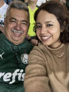 Juliane e seu pai, Raimundo, no Allianz Parque, durante um jogo do Palmeiras. Ela conta que o pai é super fanático pelo time de futebol e que, quando ganhou um ingresso do Banco Pan para assistir ao jogo, não hesitou em chamá-lo na mesma hora. Raimundo foi pela primeira vez ao novo estádio do Palmeiras nesse ano e estava muito feliz de ver o seu time de coração.