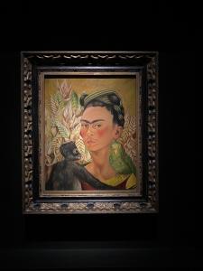 Fotografia tirada por Juliane, da obra “Autorretrato com Macaco e Periquito”, de Frida Kahlo (1942), exposta no Museu de Arte Latino-american0 de Buenos Aires – MALBA, em novembro de 2022. Juliane conta que viajou de férias para a Argentina com um amigo e foi ao Malba para ver a obra Abaporu de Tarsila do Amaral. Após a visita ao quadro, na outra sala, se deparou com a pintura de Frida Kahlo e ficou extremamente emocionada por poder ver seu trabalho de perto, passando um bom tempo refletindo sobre a obra. Juliane conheceu Frida por meio da Arte e tem muita admiração pela pintora, um exemplo de mulher forte e incrível para ela.