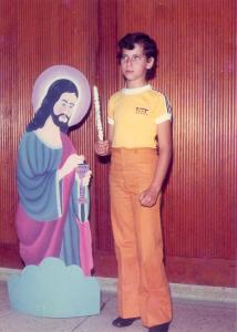 Foto ao lado da figura de Jesus Cristo em sua primeira comunhão, aos onze anos