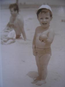 Marcelo, quando pequeno, brincando na areia da praia.