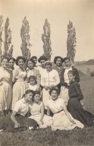 Íris com as colegas do 4º ano escolar. Está no centro da foto, de branco, olhando para baixo.