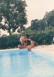 Fotografia do netos de Íris, Leonardo e Simone, à beira de uma piscina em Mairiporã. À direita, um amigo não identificado.