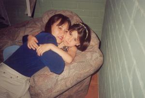 Maria Cristina e sua filha, Paula, abraçadas no sofá.