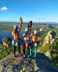 Na foto, as amigas aparecem de costas, peitos desnudos, no cume da Pedra da Galinha Choca, em Quixadá, abril de 2025. O registro vai além da escalada: é símbolo de coragem, amizade e liberdade. Para Cíntia e suas companheiras das “DIBelas” (Coletivo de mulheres escaladoras da Pedreira do Dib), chegar ao topo daquela via foi emocionante. Guiar a cordada, vencer o medo e conquistar o cume transformaram o instante em celebração. A escolha de posar assim é ritual do grupo: gesto de afirmação, de pertencimento e de libertação feminina. A imagem traduz não apenas a conquista da montanha, mas também a força de mulheres que se apoiam e se reinventam juntas.