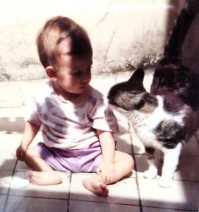 Com apenas um ano de idade, Raissa aparece ao lado de Titi, a gatinha da família, dentro da casa em que viviam naquele período. O registro foi feito de forma simples por seus pais, sem a intenção de marcar uma data especial. A fotografia revela um momento comum da vida doméstica, em que a presença do animal já fazia parte da infância e da rotina familiar, mesmo sem consciência do gesto.