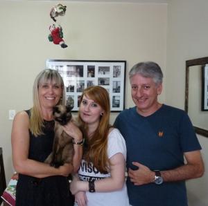 Raissa aparece ao lado de seus pais, Claudia e Bráulio, e de Samy, a gatinha da família, em uma fotografia tradicional de Natal, feita na sala de casa. O registro segue o costume familiar de reunir todos em frente à câmera, incluindo a companheira de quatro patas como parte do grupo. A imagem reforça o lugar do animal dentro da estrutura familiar, não como exceção, mas como presença constante nas celebrações.