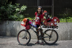 Rafaela sempre sonhou, desde 2017, em ter uma bicicleta com trenó, inspirado em um ciclista que viu pedalar na Avenida Paulista puxando um trenó no Natal. A ideia ficou marcada e, em 2018, ela decidiu que um dia faria o seu próprio. Em 2021, conseguiu transformar o sonho em realidade: desenhou o molde em papelão, levou a uma marcenaria ao lado do trabalho e o rapaz passou para a madeira. Adaptou o trenó mantendo a caixa de transporte da cachorra Mel e, em uma ação especial, colocou ração na caixa da frente para distribuir aos moradores de rua da região. Para Rafaela, o mais marcante foi perceber que aquilo que parecia apenas um pensamento distante se concretizou sem grandes planos, tornando-se um gesto de solidariedade e realização pessoal.