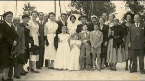 Fotografia de grupo registrada durante o casamento religioso dos pais de Louis Robin, reunindo os noivos, familiares e convidados em celebração familiar.